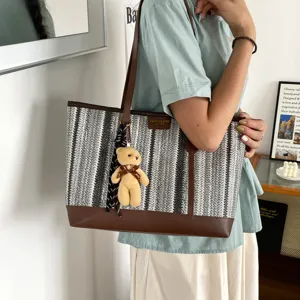 Large capacity striped woven tote bag with brown leather trim and cute bear pendant for summer.