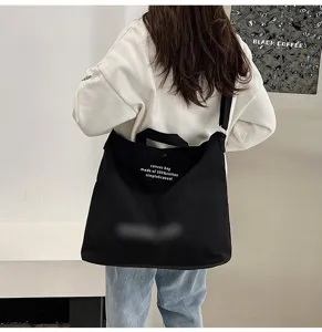 Detail de sac bandouliere en toile retro avec une grande capacite et design fourre-tout.