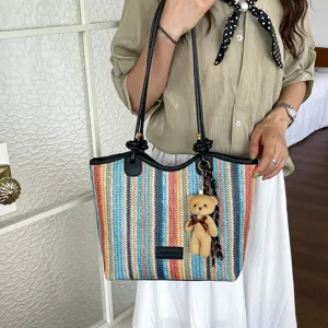 Colorful woven straw tote bag for women, stylish shoulder bag with cute bear pendant.