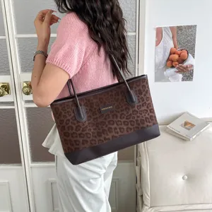 Vista dettaglio lifestyle della borsa tote leopardata elegante indossata dalla modella.