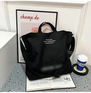 Vue détaillée du sac cabas bandoulière en toile noire, grande capacité en coton doux.