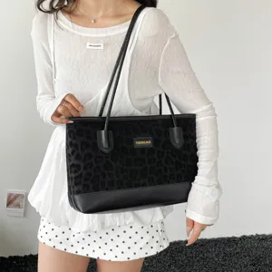 Vista di dettaglio di una borsa a spalla shopper leopardata elegante indossata, capiente.