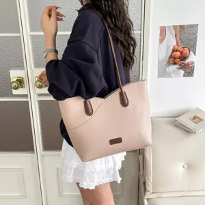 Detail shot of casual women's pink tote bag with contrast brown straps and pocket design.