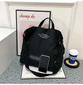 Détail de sac cabas en toile noire, grand sac bandoulière décontracté pour étudiantes.
