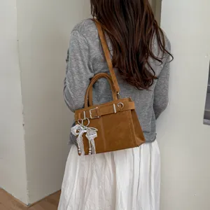 Retro brown leather handbag with belt buckle and lace pearl pendant for women fashion commute.