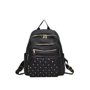 Black oxford cloth backpack for women with quilted rivet design and gold zippers, front view.