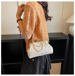 Elegant white lace kiss-lock evening bag with gold chain strap and pearl handle detail.