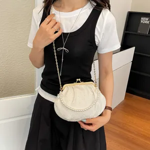 Vue détaillée du sac coquillage en dentelle plissée élégante avec poignée perle et chaîne dorée.