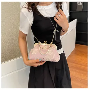 Elegant vintage pink lace embroidered kiss-lock handbag with pearl handle and chain strap.