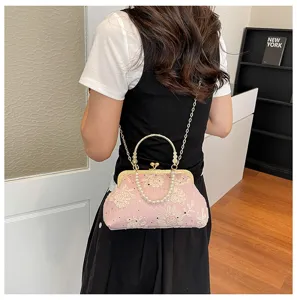 Detail view of the elegant pink floral embroidered evening bag with pearl handle and chain.