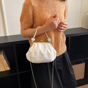 Vue détaillée d'un sac clutch blanc plissé élégant avec poignée en perles et chaîne dorée.