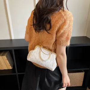 Elegant retro evening bag with delicate white embroidery, pearl handle, and chain strap.