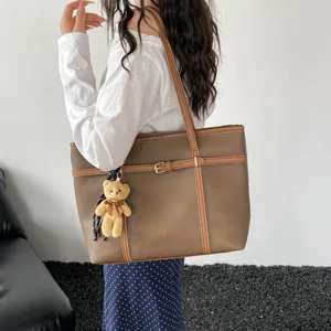 Retro texture large capacity shoulder handbag with chic belt detail and cute bear charm.