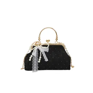 Vintage black evening bag with gold frame, pearl chain, and elegant lace bow for women.