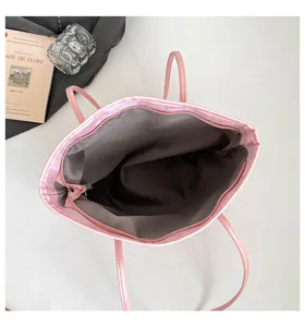 Détail intérieur de sac cabas rose avec compartiment spacieux, fermeture éclair et doublure.