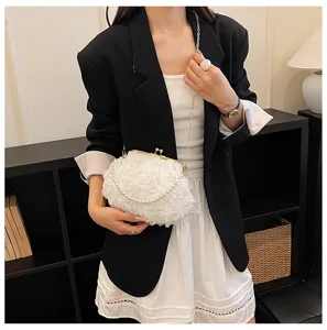 Elegant white floral pearl chain evening bag detail shot, chic kiss-lock clutch for women.