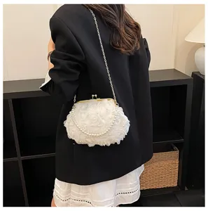 Detail view of white floral clutch bag with pearl chain strap and metallic kiss-lock closure.