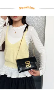 Detailed view of the black shiny chain crossbody bag with unique gold clasp, elegant style.