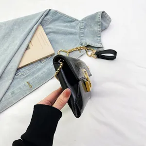 Minimalist black glossy chain crossbody bag detail, stylish women PU leather shoulder handbag.