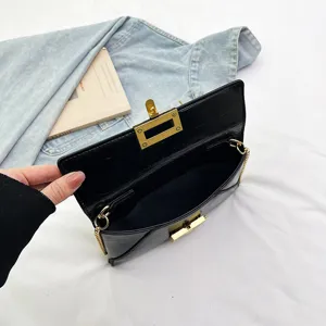 Detailed view of stylish black chain crossbody bag with gold hardware and elegant flap closure.