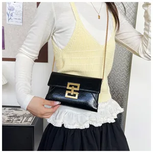 Black chain crossbody bag for women, minimalist shoulder bag with stylish metal lock design.