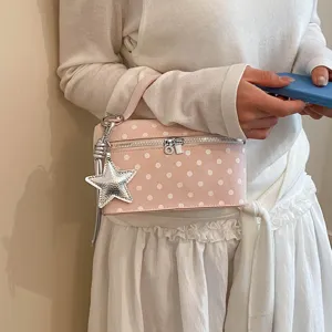 Detailed close-up of pink polka dot cosmetic vanity bag featuring a stylish silver star charm.