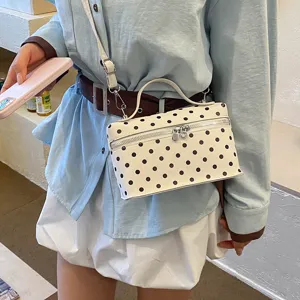 Detailed view of trendy white polka dot box handbag, chic crossbody bag for women daily.