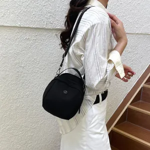 Gedetailleerd overzicht van een zwarte, lichte, casual crossbody schelpvormige schoudertas.