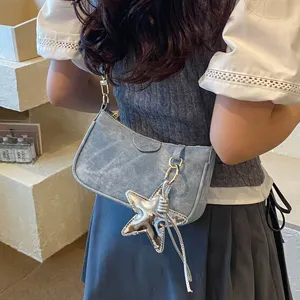 Trendy washed denim shoulder bag with silver star pendant for women stylish daily wear.