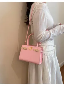 Pink fashion shoulder bag detail showing premium leather texture, metal hardware and strap.