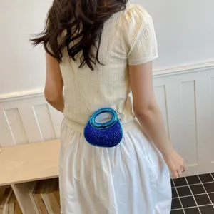 Détail de sac bandoulière à sequins chic avec poignée anneau bleu et chaîne métal femme.