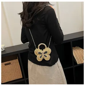Gold butterfly shaped evening bag detail shot, elegant metal chain shoulder crossbody bag.