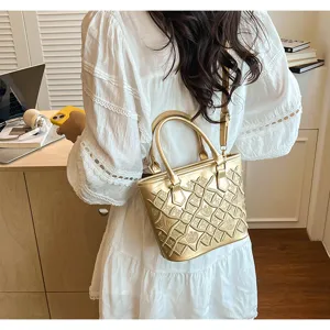 Golden bucket bag detail shot featuring exquisite stitched lattice pattern and elegant shoulder strap.