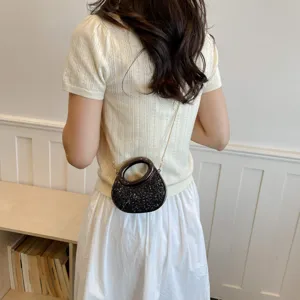 Vue de détail montrant un sac bandoulière tendance à sequins avec poignée ronde et chaîne.