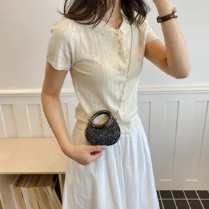 Gros plan sur le sac bandoulière pailleté stylé avec poignée anneau et chaîne en tenue.