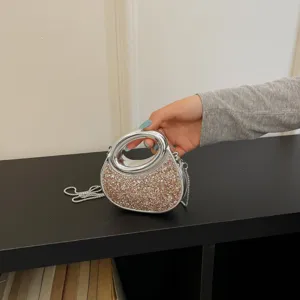 Vue détaillée d'un sac à main élégant recouvert de sequins avec une poignée ronde argentée.