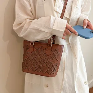 Brown embossed tote shoulder bag with stylish woven pattern and adjustable strap design.