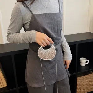 Gros plan détail d'un sac bandoulière tendance à paillettes avec chaîne argentée.