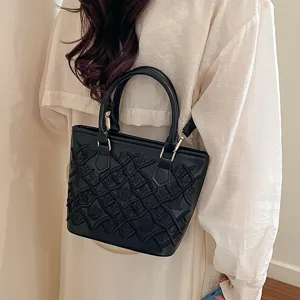 Black textured bucket handbag with chic grid embroidery, stylish shoulder bag for women.