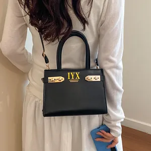 Fashionable women's black leather handbag with top handle and crossbody strap for daily use.