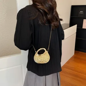 Vue détaillée du sac à bandoulière élégant et doré à sequins avec chaîne et poignée.