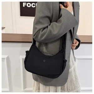 Detail view of casual black nylon crescent shoulder bag, lightweight crossbody design.