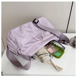Lightweight nylon purple grid crossbody bag detail showing spacious capacity, strap and zip.
