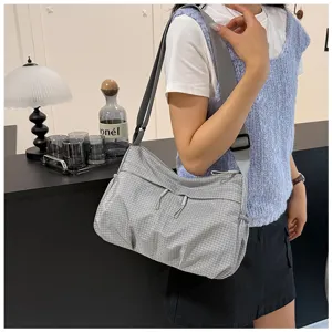 Grey grid nylon crossbody bag detail, casual lightweight shoulder bag with front zipper pocket.