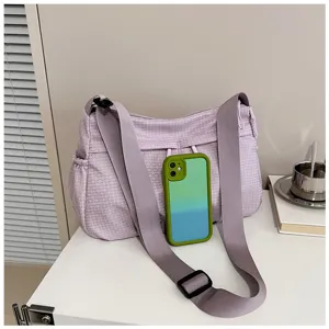 Close-up detail of the casual purple grid crossbody bag with wide strap and spacious interior.