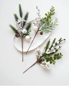 Detailed view of artificial Christmas botanical picks with pine needles and white berries.