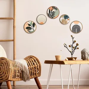 Detalle de arte de pared de madera boho con hojas abstractas y sol en una habitación acogedora.