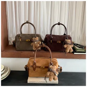 Schicke Wildleder Boston Tasche mit Bärenanhänger, stilvolle Damentasche für den Herbst.