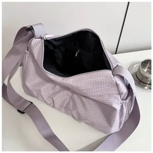 Detail view of the minimalist purple grid nylon crossbody shoulder bag with secure zipper.