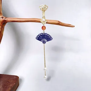 Detailed shot of Chinese traditional style fan tassel pendant accessory with delicate golden chain.